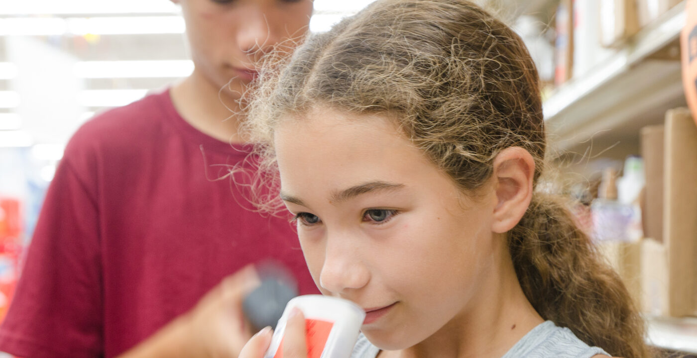 Young girl and boy in a store aisle examining deodorants