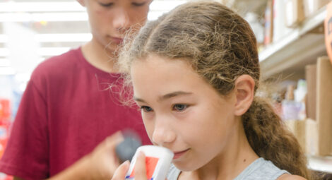 Young girl and boy in a store aisle examining deodorants