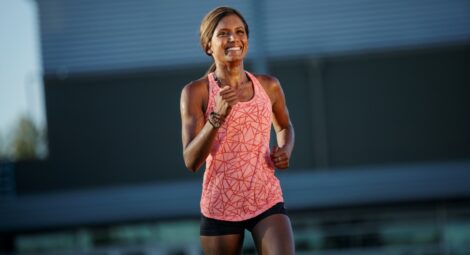 Woman in exercise clothing running outdoors in the sun
