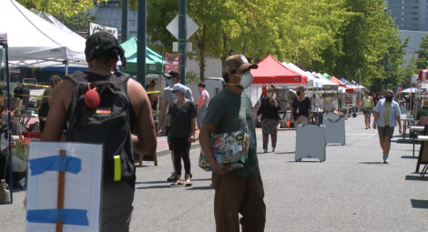 People walking around masked at a farmers markert