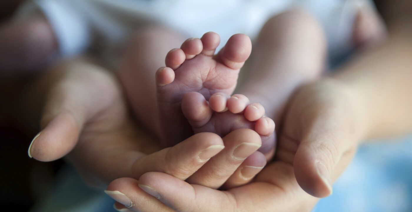 Woman holding baby showing feet