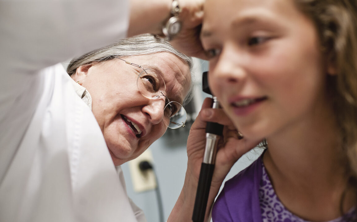 Medical professional looking into a patients ears