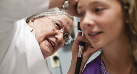 Medical professional looking into a patients ears