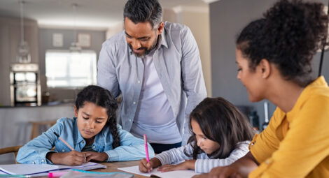 Parents watching two children doing homework
