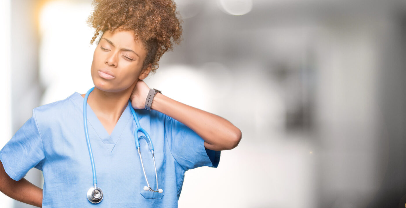 Health care worker grabbing her neck because of pain