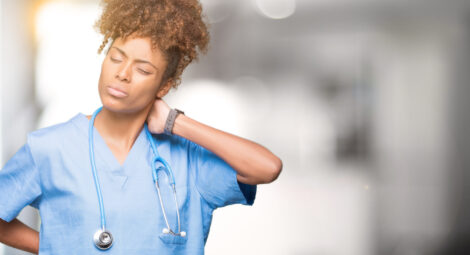Health care worker grabbing her neck because of pain