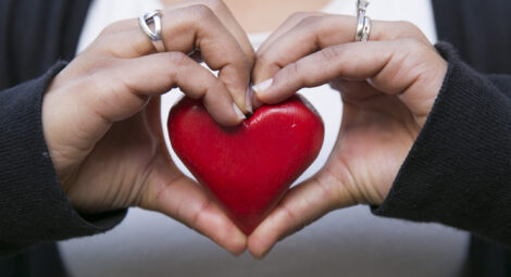 Hands around a heart shape.