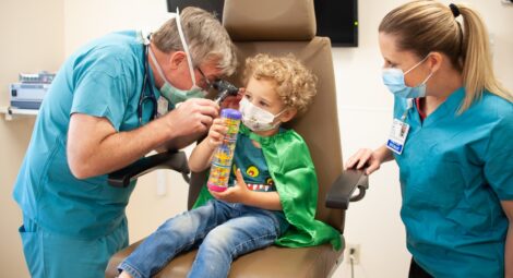 Child having his ears checked by medical professionals