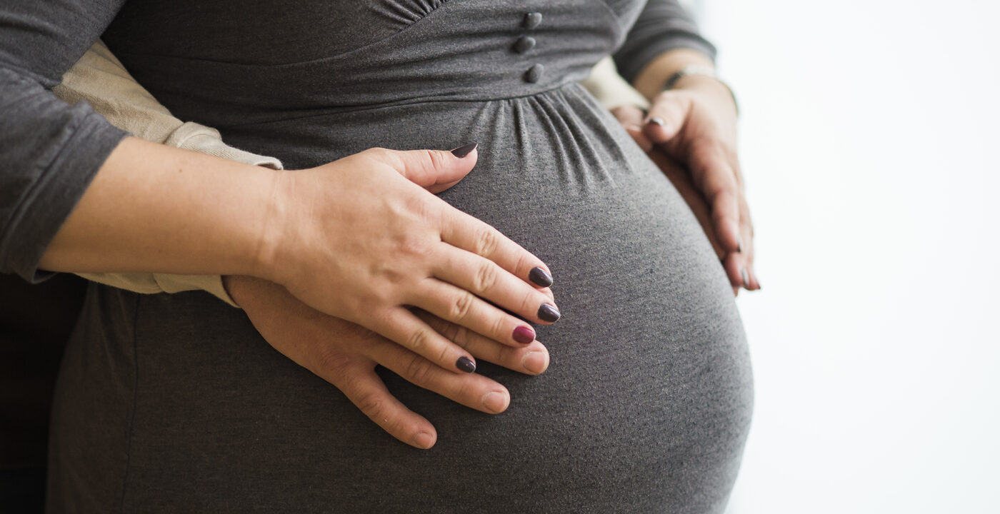 Pregnant woman holding belly