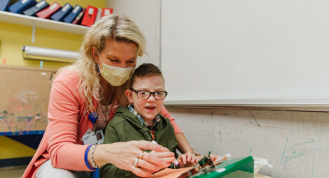 Boy with special needs working on a tool with a hospital worker