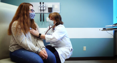 Doctor listening to a teenagers heart beat