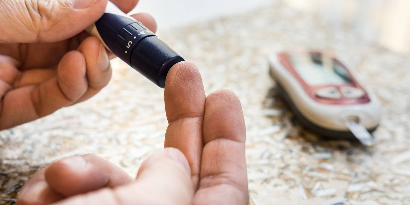 Diabetic man checks blood sugar levels with glucose meter