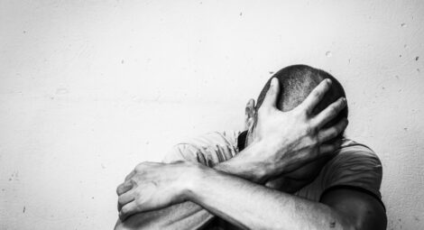 Man grabbing his head hiding his face