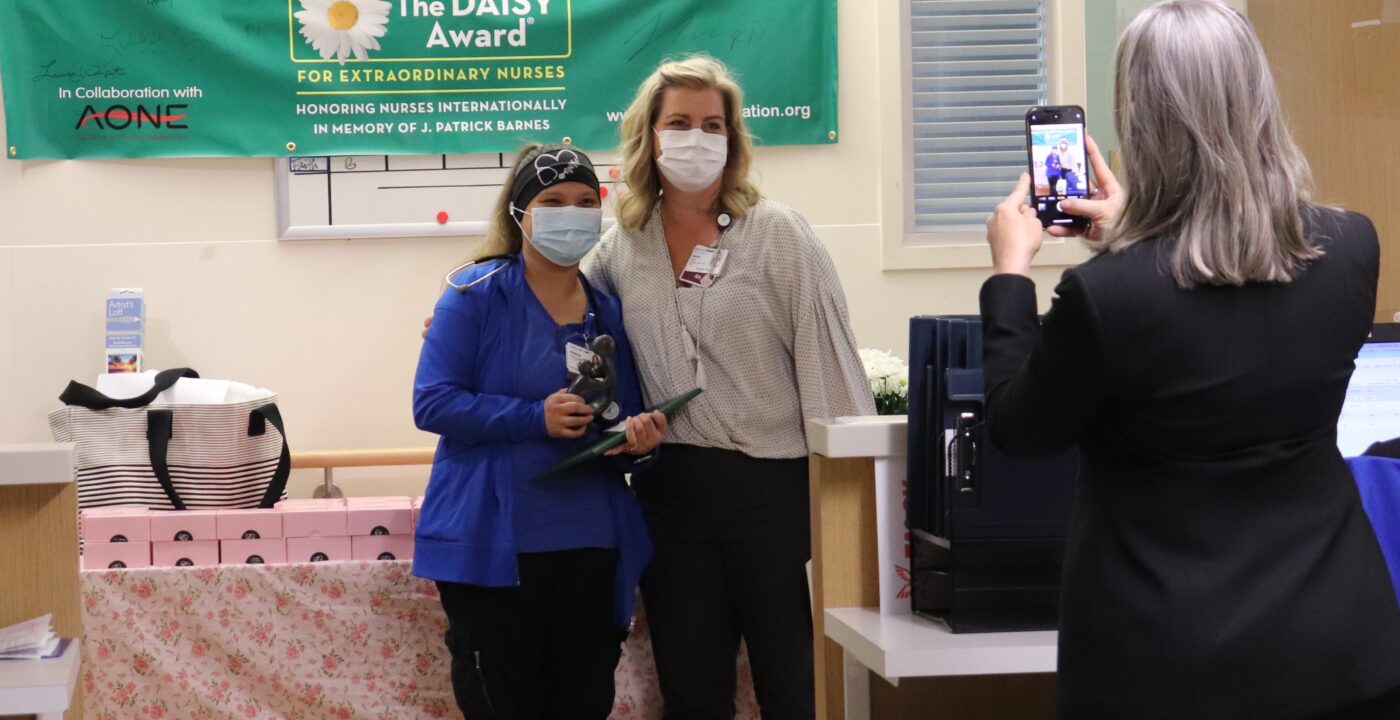 Melanie Ives, RN, and nurse manager Sarah Post, RN, pose for photos during the Daisy Award presentation ceremony