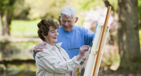 Older couple painting together outside