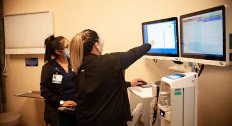 Two medical professionals looking at a screen with medical results