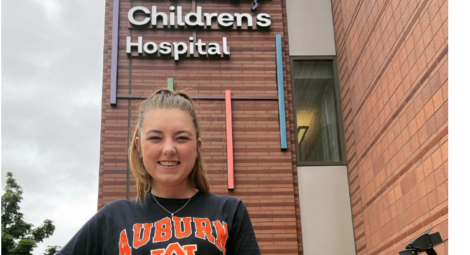 College age female standing in front of children's hospital