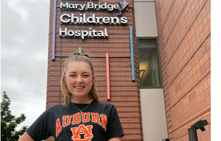 College age female standing in front of children's hospital