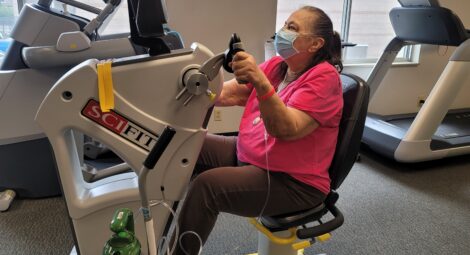 Woman on exercise machine hooked up to oxygen