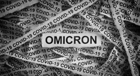 Strips of newspaper with the words Omicron and Covid-19 typed on them.