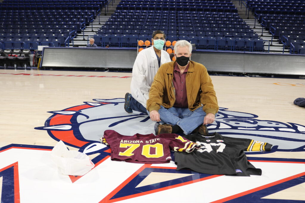 Man and doctor sitting on a basketball court 