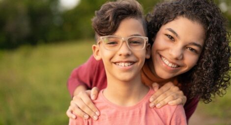 Brother and sister smiling in a field