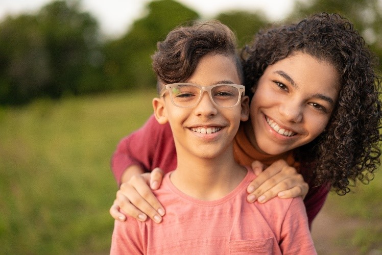 Brother and sister smiling in a field