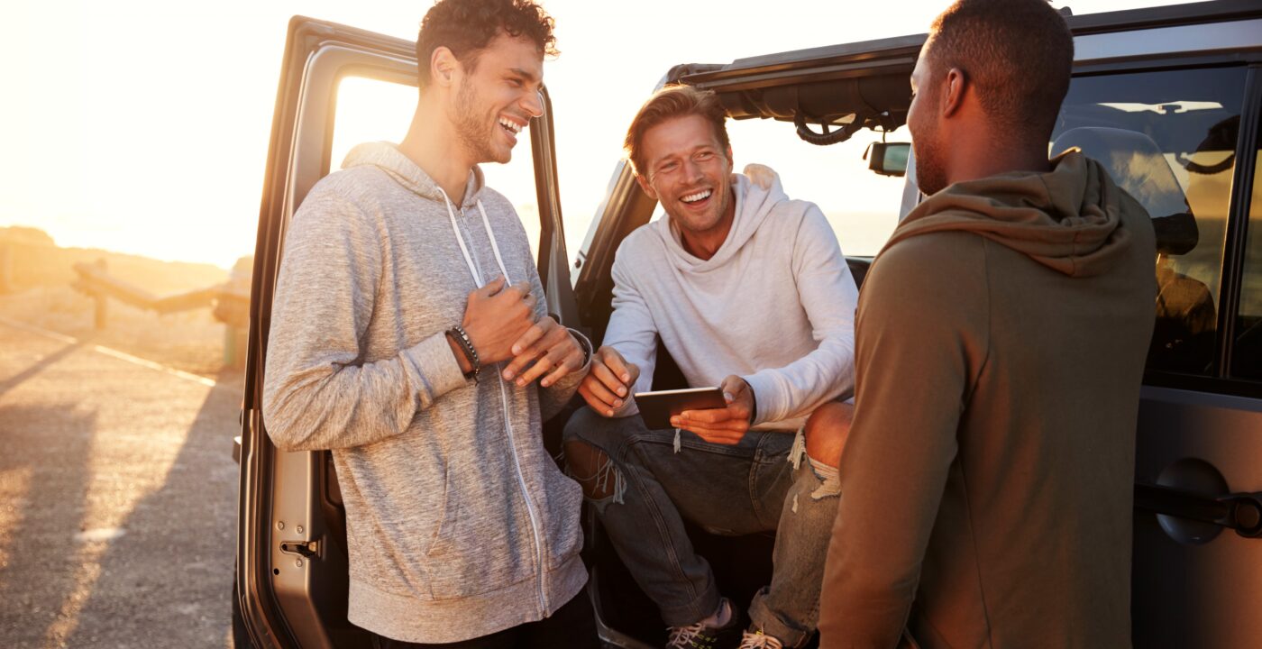Three men standing near a car