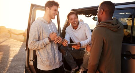Three men standing near a car