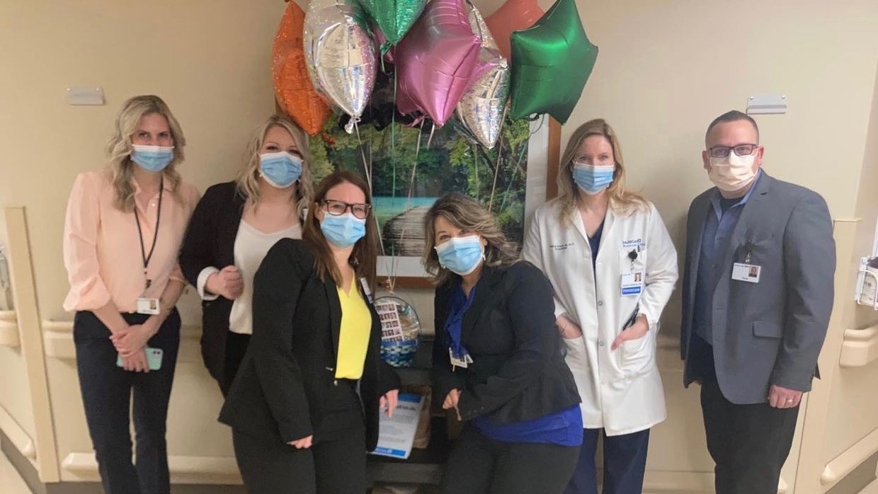 Staff posing for camera with balloons