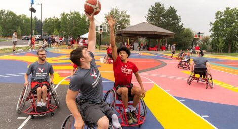 Men playing adaptive basketball in wheelchairs