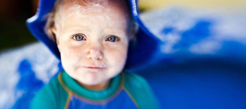 Toddler wearing sunscreen and a hat