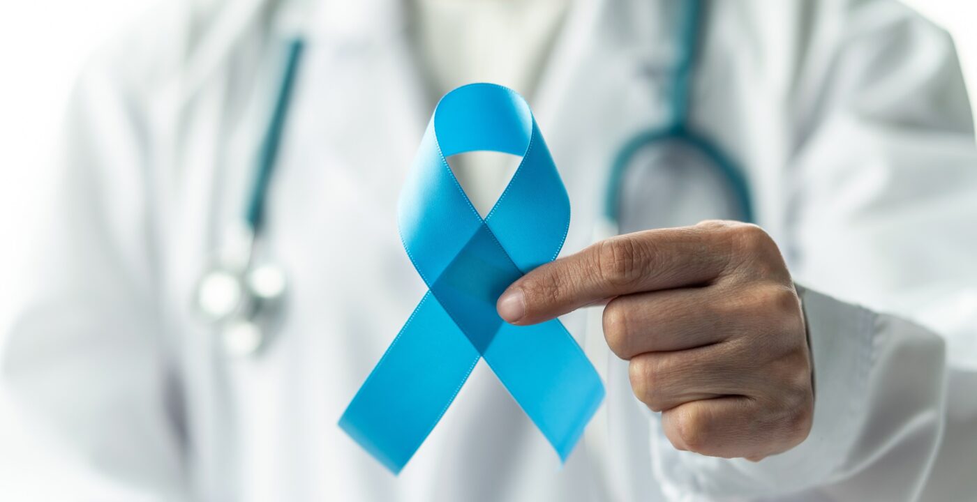 Man with stethoscope holding a blue ribbon.