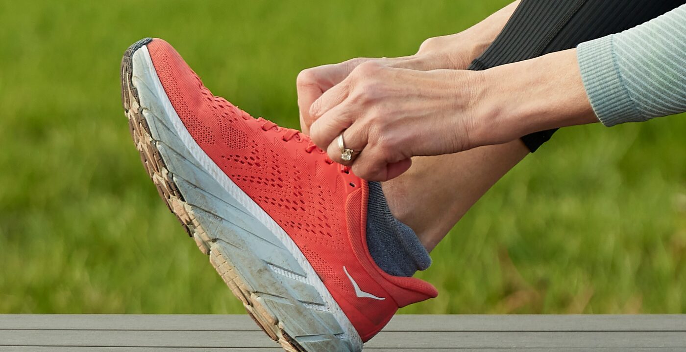 Close up of a hand tying a running shoe.