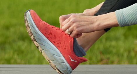 Close up of a hand tying a running shoe.