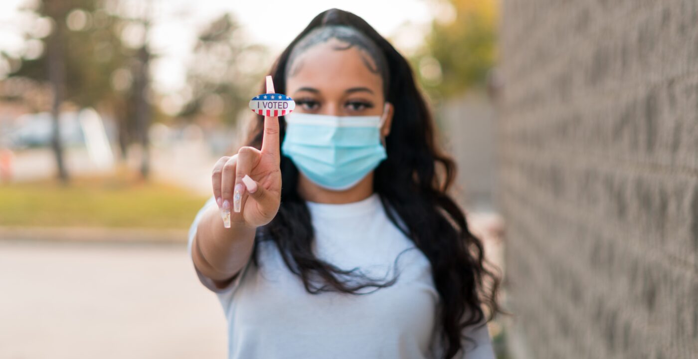Masked female holding up a 