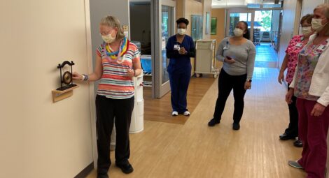 Woman ringing a gong in celebration of beating cancer.