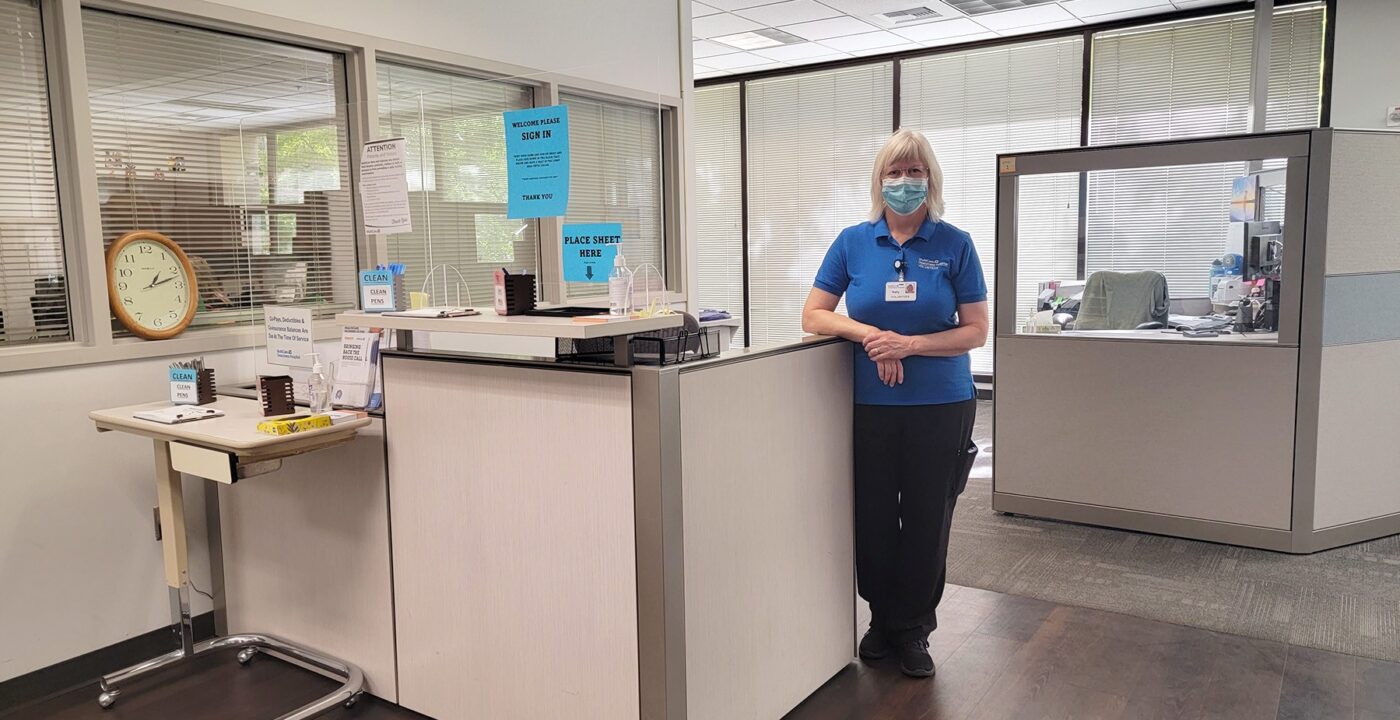 Hospital worker standing in front of a desk.
