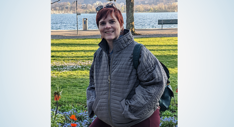 Woman with short hair wearing coat at waterfront park