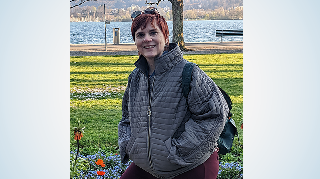 Woman with short hair wearing coat at waterfront park