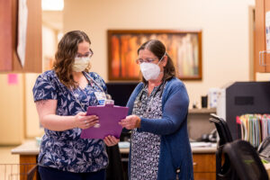 Woman doctor talking with staff.