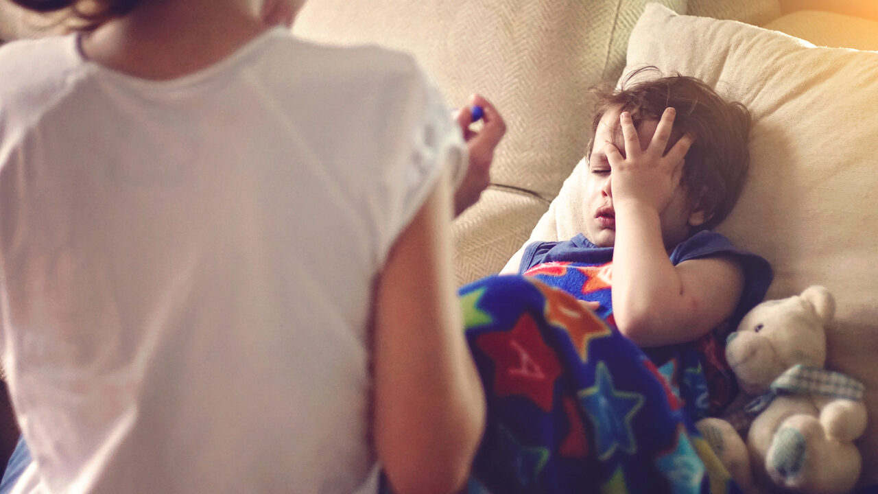 Boy grabbing his head in pain.