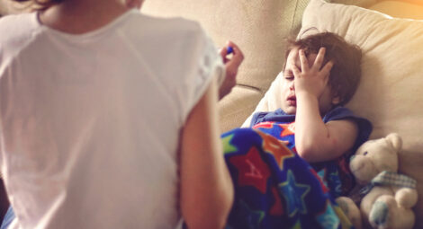 Boy grabbing his head in pain.