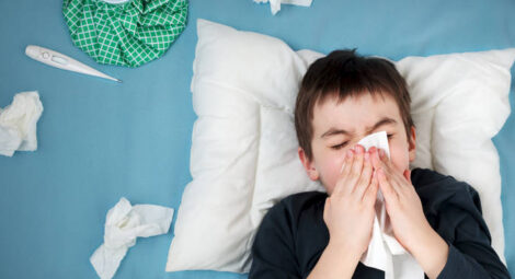 Boy blowing his nose.