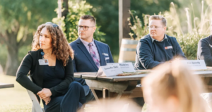 People at a table listening to someone talk.