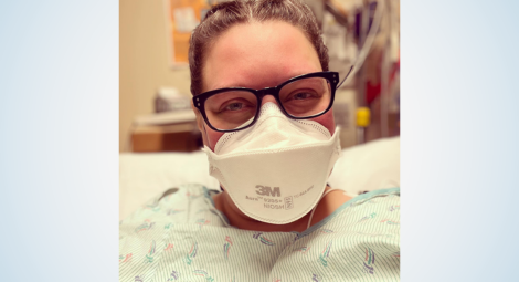 Woman in glasses, face mask and hospital gown in patient room