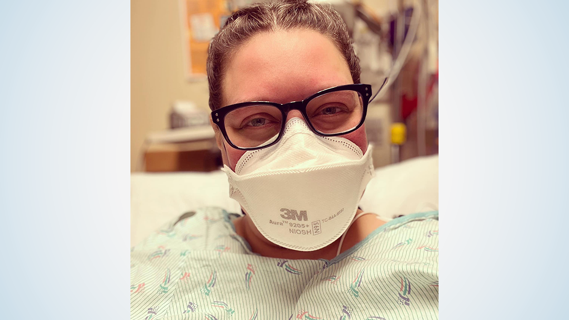 Woman in glasses, face mask and hospital gown in patient room