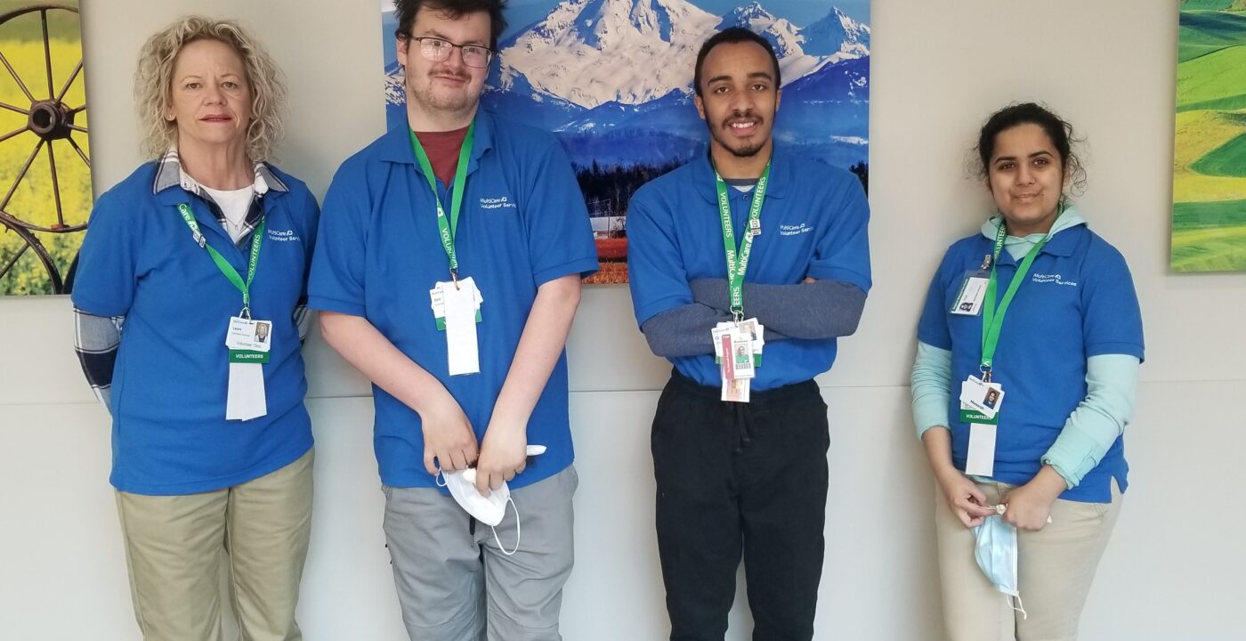 Four volunteers in blue MultiCare shirts