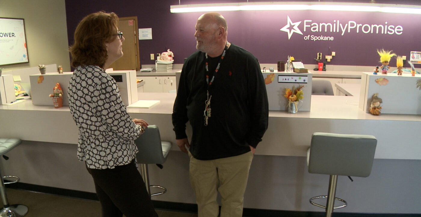 Man and woman talking in front of a desk