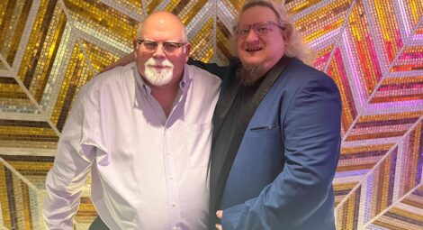 Two men standing in front of a shiny tiled wall